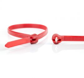 Een rode Ty-Rap® kunststof kabelbinder, naast een uitvergrote sluiting van een andere Ty-Rap® kabelbinder.;De sluiting van een rode Ty-Rap® kunststof kabelbinder uitvergroot, naast een uitvergrote kop van een andere kabelbinder.